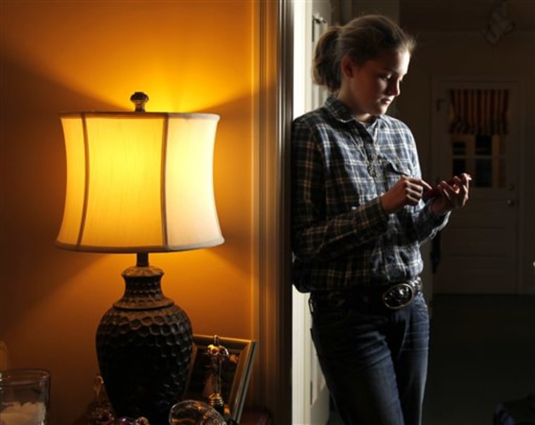 Taylor Smith checks her Twitter feed while posing for a photograph at her home in Kirkwood, Mo.